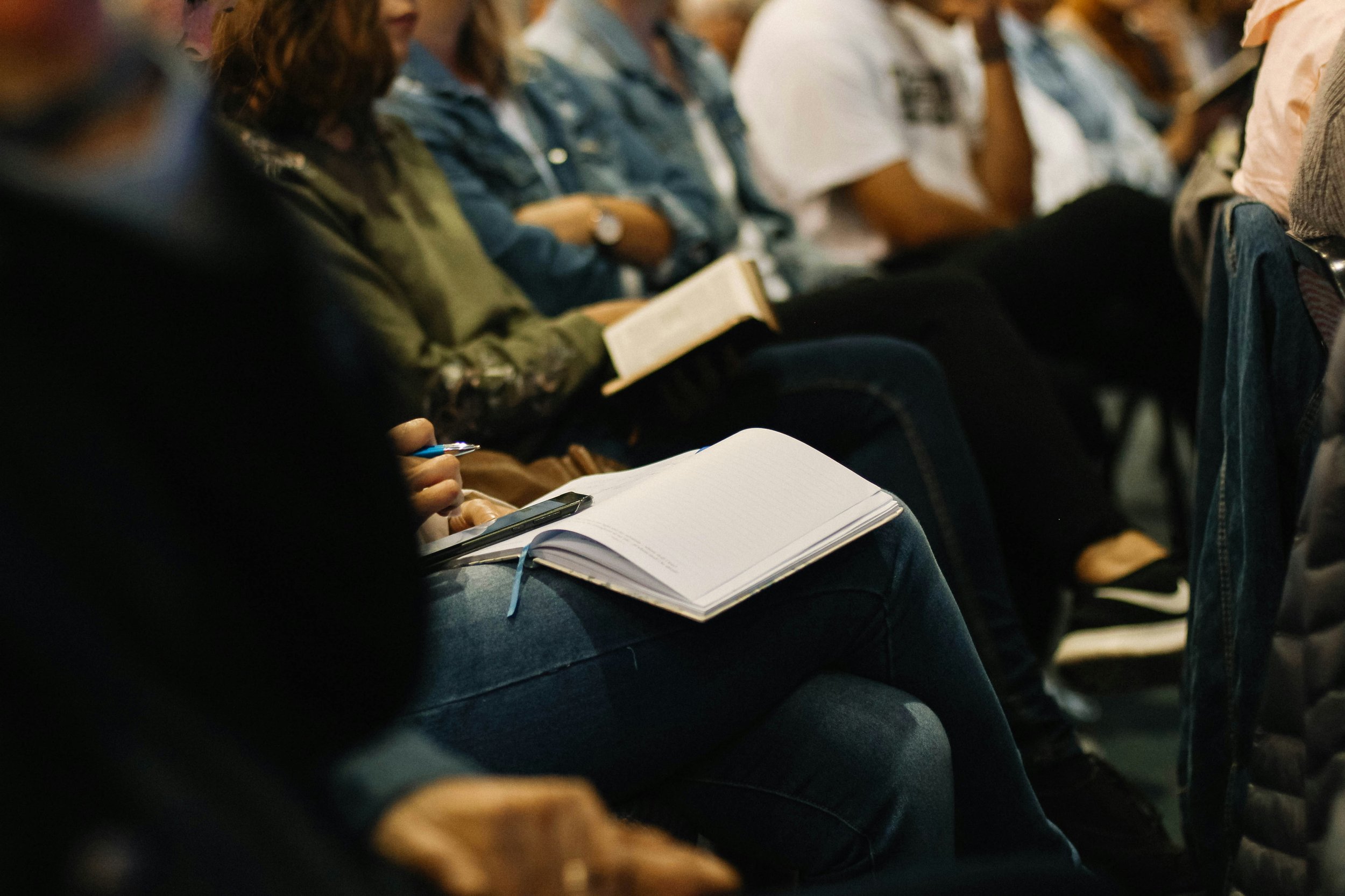 People taking notes at a Celebrate Recovery meeting
